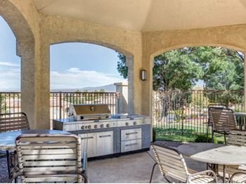 A patio with a grill and tables and chairs